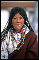 A female Tibetan pilgrim eating candy in front of the Jokhang. Lhasa, Tibet, China