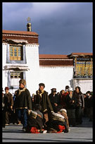 Tibetan pilgrims wearing chubas (long-sleeved sheepskin cloaks). Lhasa, Tibet, China