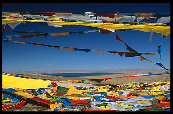 Prayer flags on the last mountain pass before Nam Tso. Lake Nam Tso appears in the background.