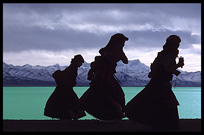 Tibetan pilgrims, anxious to finish their Nam Tso Kora, run for the bad weather. Nam Tso, Tibet, China