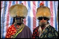 Two very colourful Tibetan pilgrims at walking the Kora at Nam Tso. Nam Tso, Tibet, China