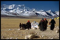 Tibetan pilgrims walking the Nam Tso Kora with the Nyenchen Tanglha massif (7111m) in the background. Nam Tso, Tibet, China