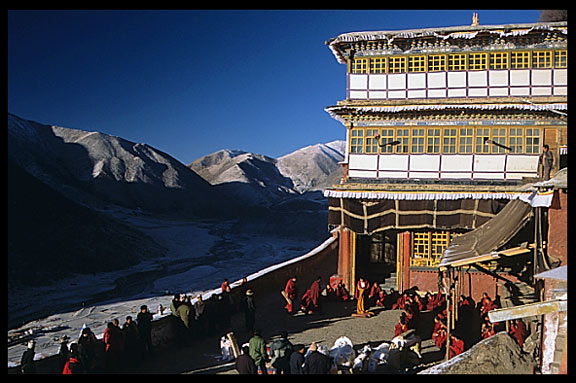 Tibetans travel hundreds of kilometers to bring their deceased relatives to Drigung Til monastery for a sky-burial. Monks receive gifts in the main courtyard just before the sky-burial begins.