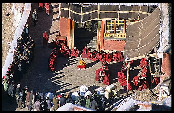 Tibetans travel hundreds of kilometers to bring their deceased relatives to Drigung Til monastery for a sky-burial. Monks receive gifts in the main courtyard just before the sky-burial begins.